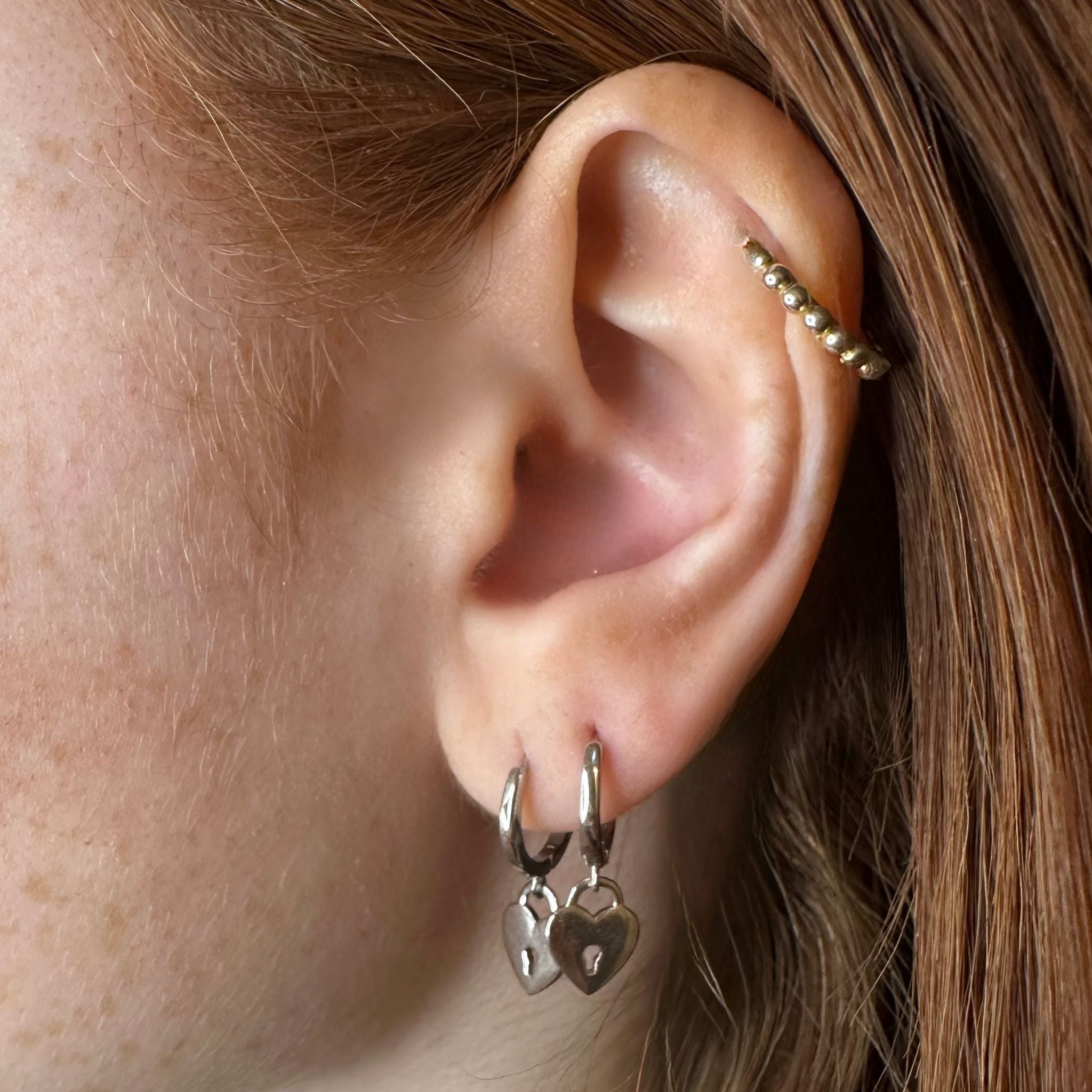 Boucles d'oreilles LOCK Silver argent rhodié portées, créoles cœur-cadenas pop et résistantes à l'eau.