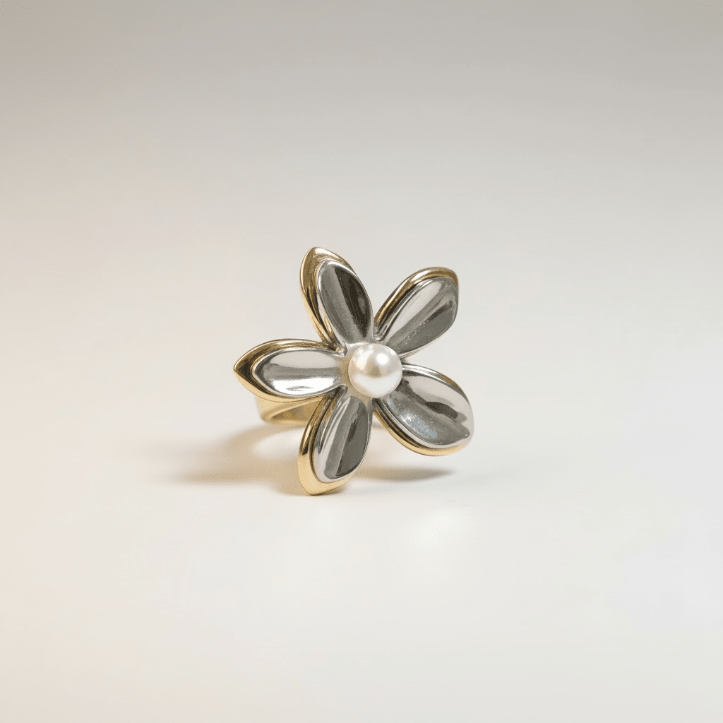 Bague Bloom — florale sculptural bicolore gold & silver en acier PVD or 18k. Perle centrale, ajustable, waterproof, hypoallergénique. Statement couture tendance.