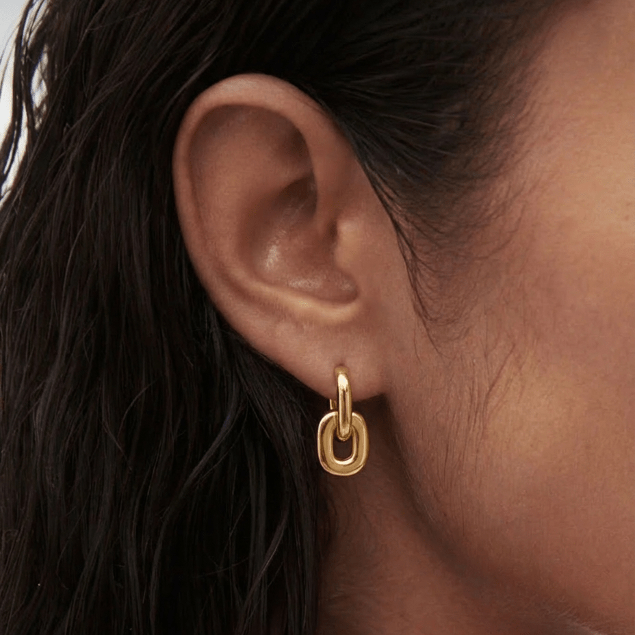 Créoles Mila en argent 925 plaqué or 18k avec charm amovible. Deux looks en une paire — légères, hypoallergéniques et waterproof. Livraison offerte au Benelux.