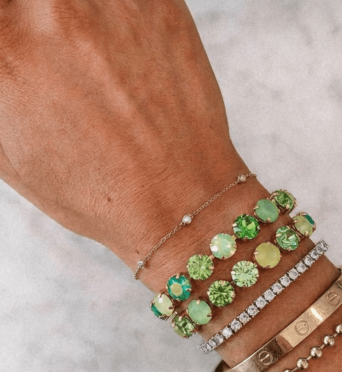 Bracelet Lime Luxe — cristaux verts irisés sur acier inoxydable doré. Fermoir ajustable, waterproof, hypoallergénique. Effet glow vibrant à 24,90€.