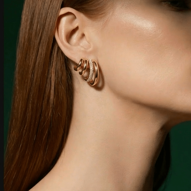 Boucles Golden Flow — design fluide sculptural, zircons incrustés en acier PVD or 18k. 2,4x2,5cm, 10,8g, waterproof, hypoallergéniques. Statement élégant. vue portée