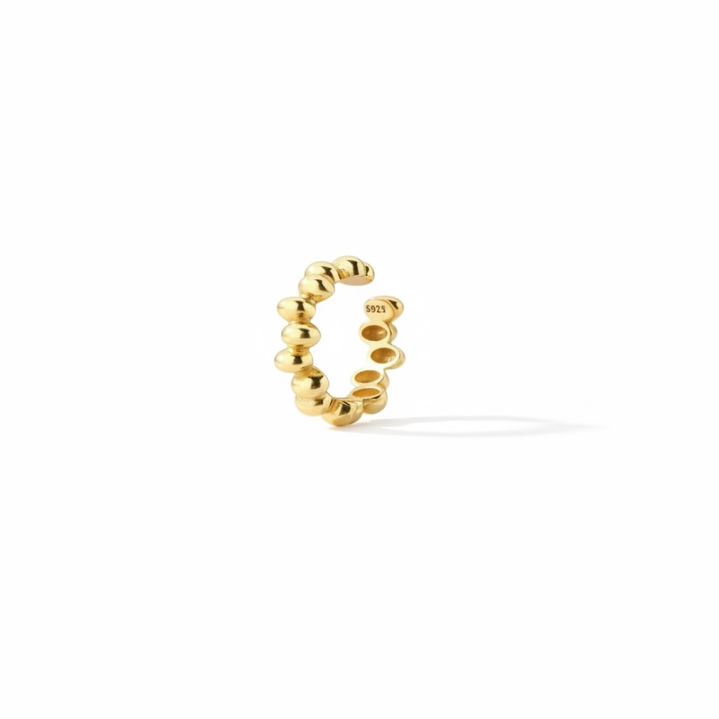 
Ear Cuff Glossy Gold — relief perles bombées en argent 925 plaqué or 18k. 10mm, 1,2g, sans piercing, hypoallergénique, résistant à l'eau. Minimaliste et lumineux.