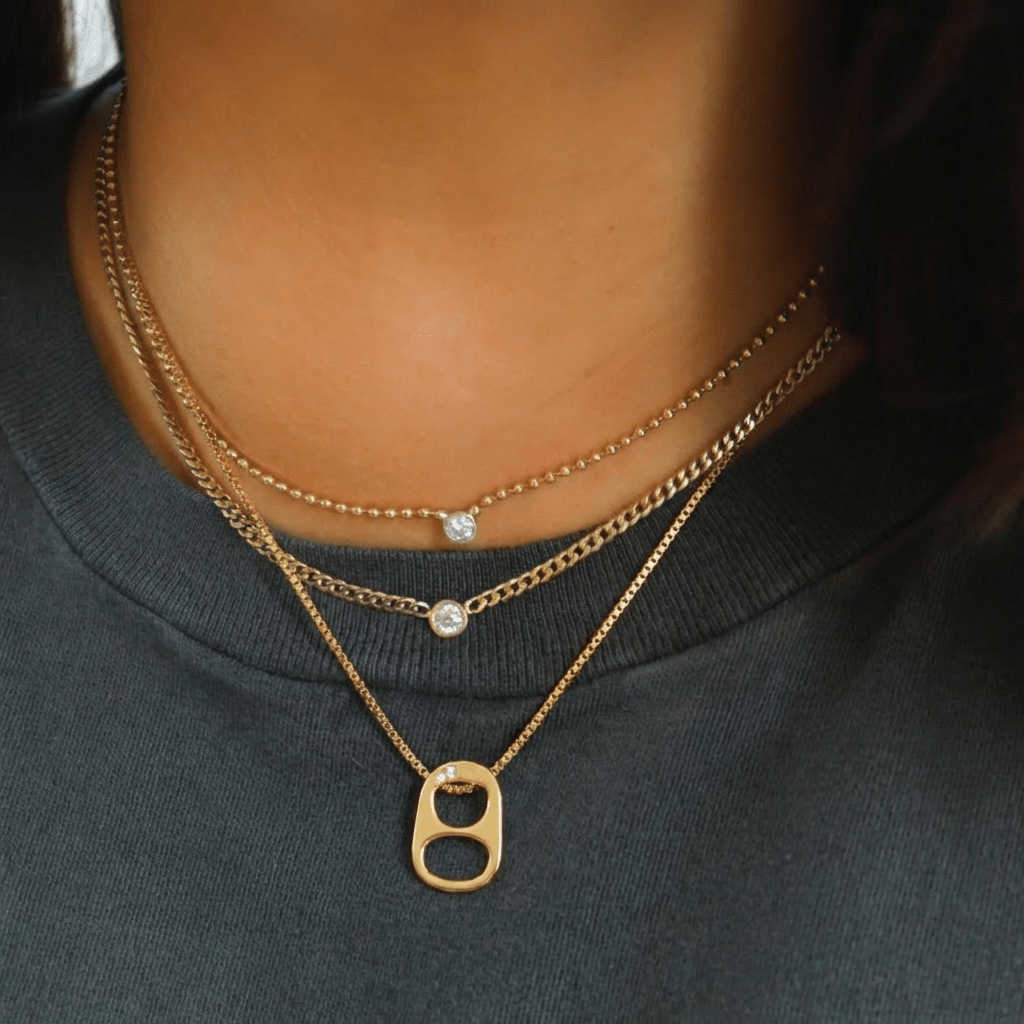 Collier Baddie Spark Gold — pendentif capsule canette en laiton doré & zircon. 40+5cm, fermoir mousqueton. Pop-culture assumée. Non waterproof.