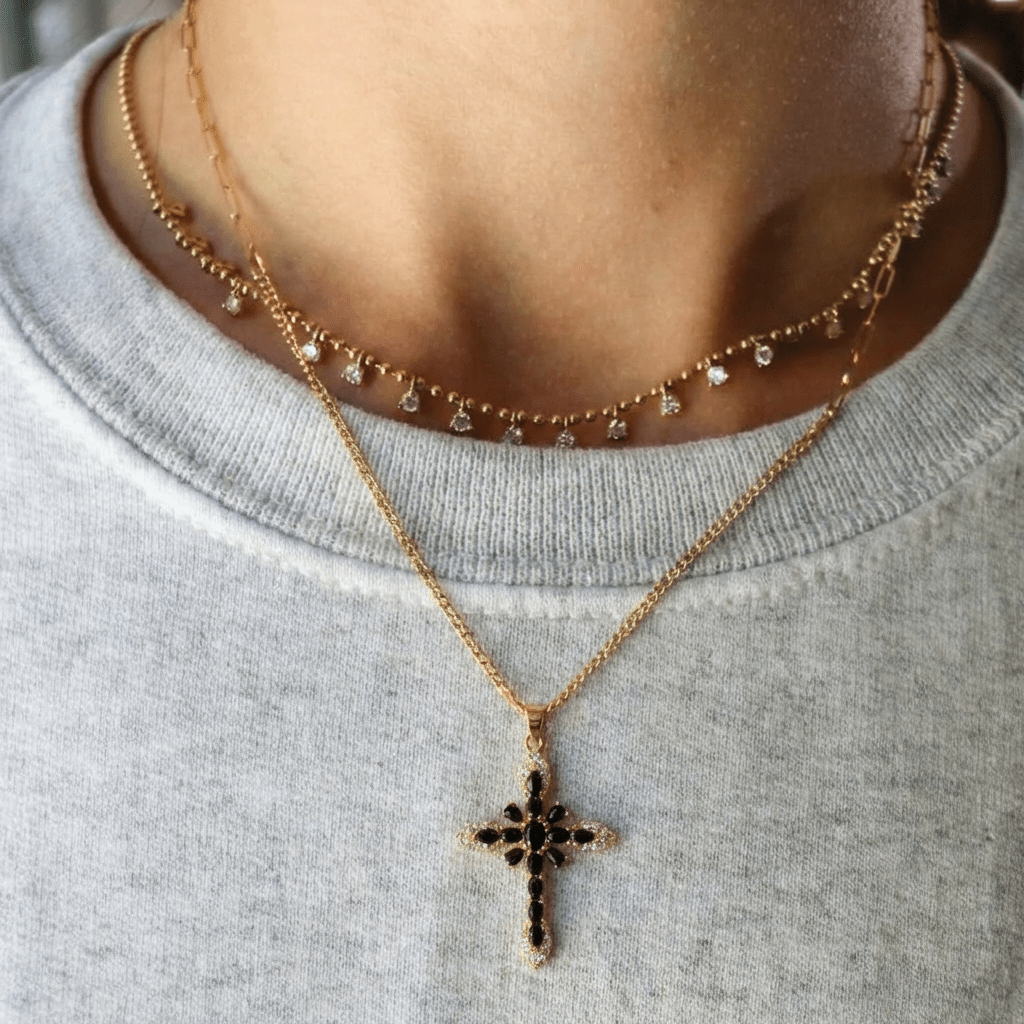 Collier Midnight Icon — croix zircons noirs en acier PVD or 18k. 31x21mm, waterproof, hypoallergénique. Contraste doré/noir puissant et élégant à 24,90€.
vue porté