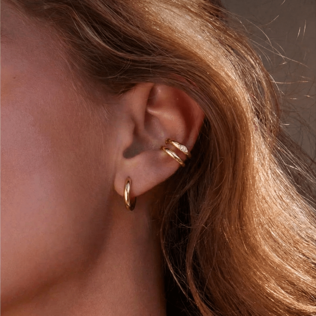 Ear Cuff Muse Gold — double anneau argent 925 plaqué or 18k & zircone goutte. Sans perçage, hypoallergénique, résistant à l'eau. Double piercing doré intense.