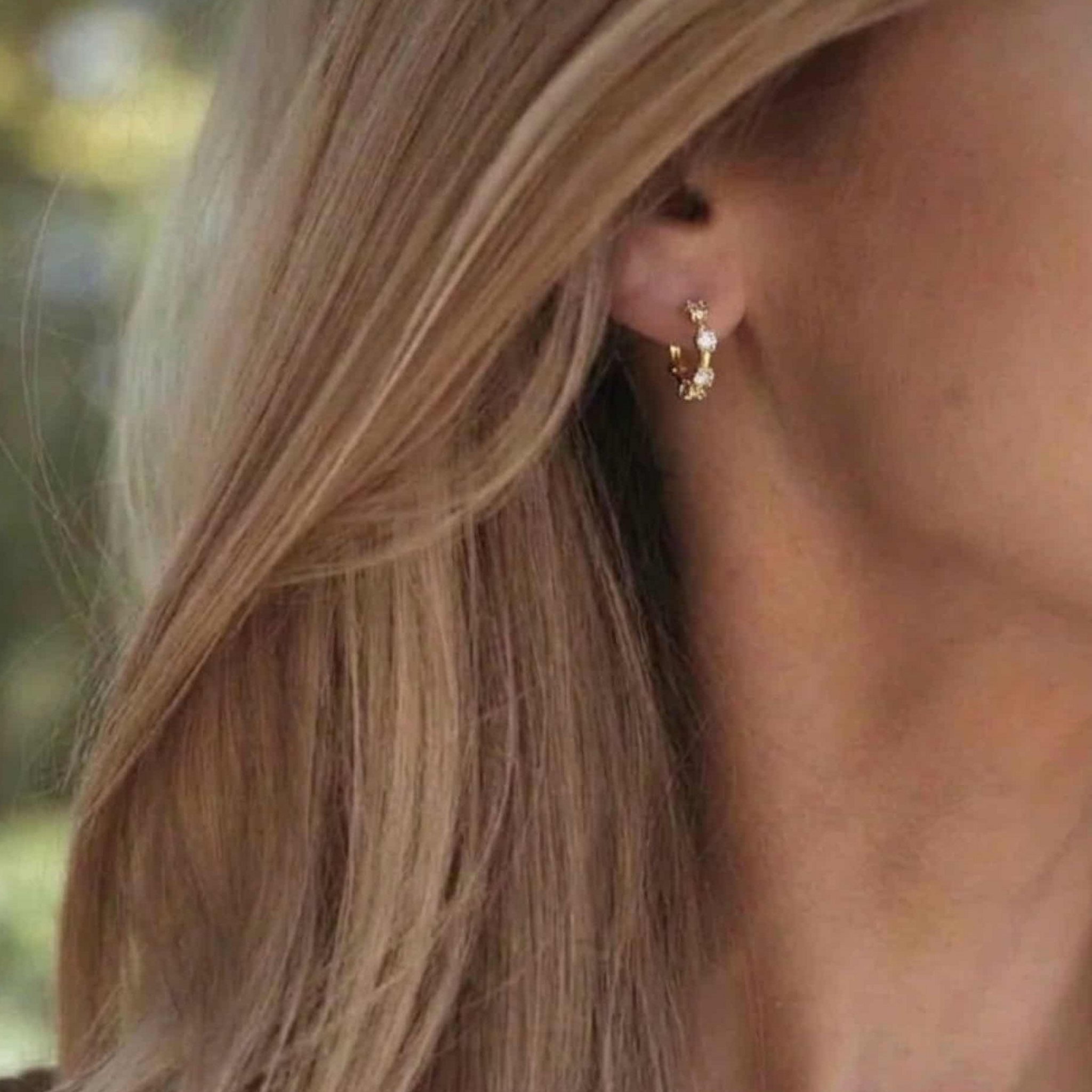 Mini créoles Lola en argent 925 plaqué or 18k & 5 zircones éclat diamant. Diamètre 9,6mm, hypoallergéniques, résistantes à l'eau. Discrètes et inoubliables. vue portée sur femme blonde 