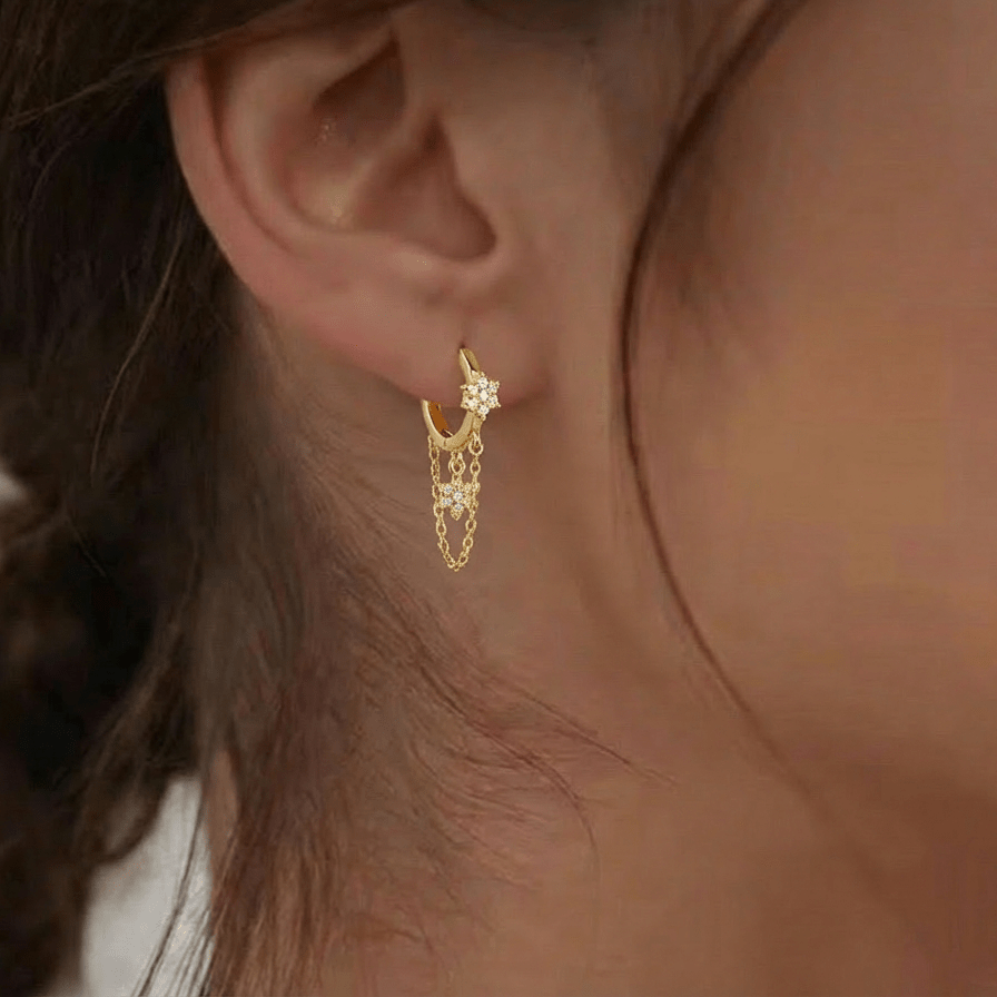 Mono boucle Iris Gold — fleur & étoile pavées zircons en argent 925 plaqué or 18k, chaînette fine. Hypoallergénique, résistante à l'eau. Éclat floral doré.
Luxlab Collection vue portée 